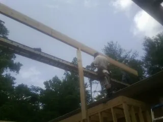 Carpenter setting a ridge beam over a new addition frame — Ice Dam Removal by Roofing Brothers in Bethel